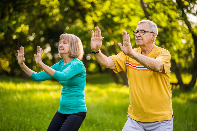 personas haciendo tai chi en el parque