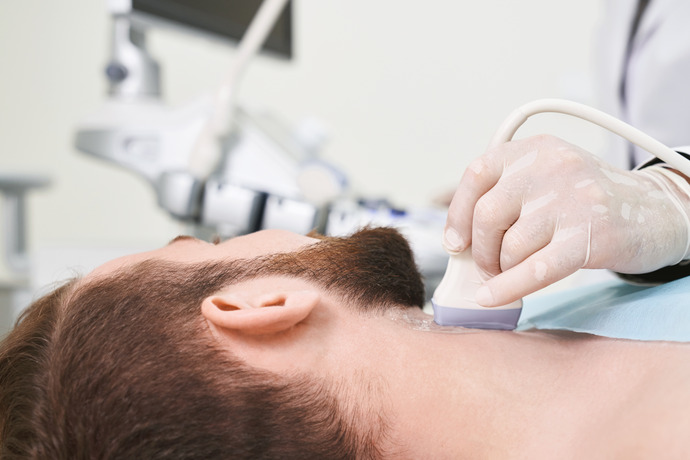 Doctor examinando si un bulto en el cuello de su paciente es malo.