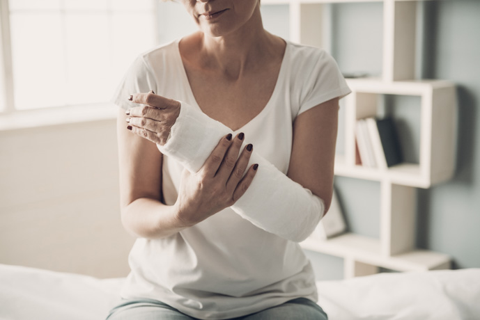 Mujer con el brazo roto por fluorosis esquelética.