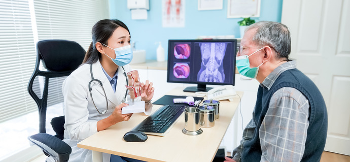 Doctor mostrando un modelo rectal a un paciente