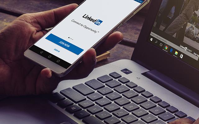 Persona viendo su celular con la app de Linkedin